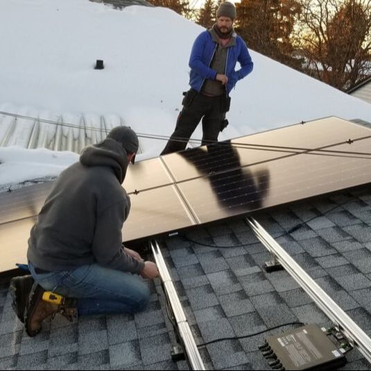 Two men installing a PV array on a roof